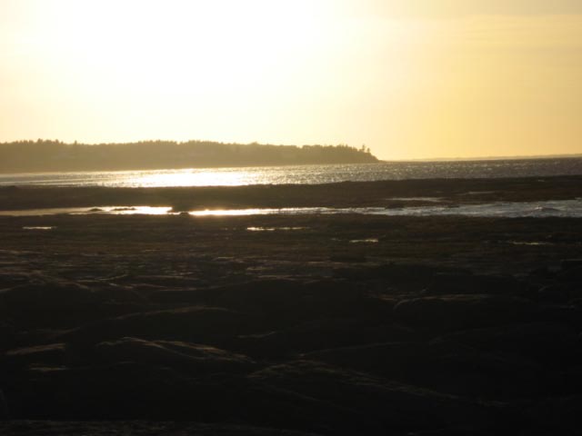 Het strand nabij Lorneville bij zonsondergang